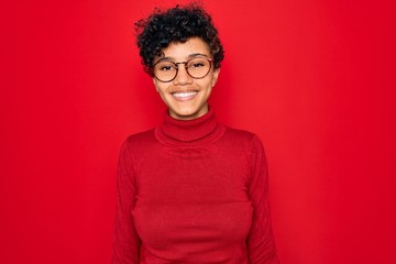 Obraz premium Young beautiful african american afro woman wearing turtleneck sweater and glasses with a happy and cool smile on face. Lucky person.