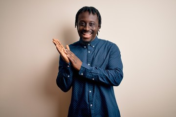 Young handsome african american man wearing casual shirt standing over white background clapping...