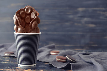 Cup with delicious sweet bubble waffle on dark wooden background