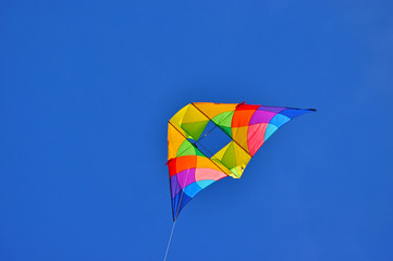 A colorful kite flying in the blue sky