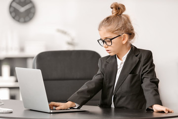 Little businesswoman with laptop working in office