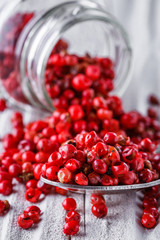 pink peppercorns on white wooden rustic background