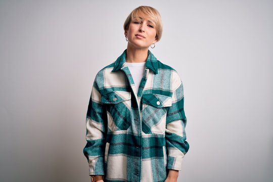 Young blonde woman with short hair wearing casual retro green shirt over isolated background Relaxed with serious expression on face. Simple and natural looking at the camera.