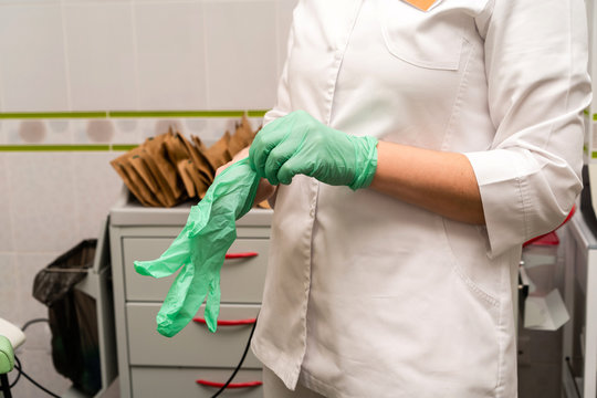 Medical procedures in the office of the ENT specialist. Otorhinolaryngologist doctor pediatrician therapist. Doctor putting rubber gloves on hands. Family reception at a private clinic