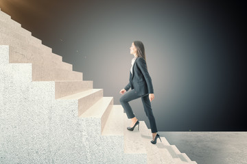 Side view of businesswoman climbing on stairs.