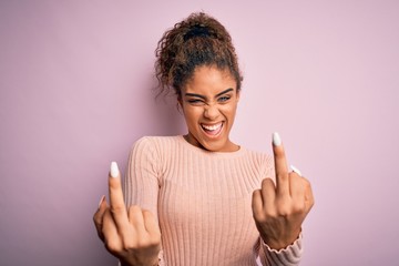 Young beautiful african american girl wearing casual sweater standing over pink background Showing...