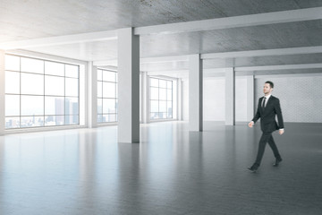 Businessman walking in minimalistic gallery interior