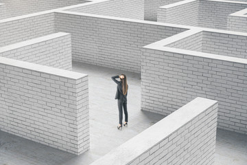 Businesswoman standing in middle of a brick maze.