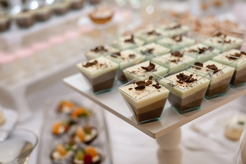 Sweet table for birthday or wedding ceremony. Candy bar with a lot of different candies and sweet cakes. Selective focus. Party and holiday celebration concept