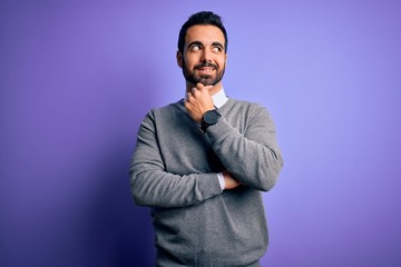 Handsome businessman with beard wearing casual tie standing over purple background with hand on chin thinking about question, pensive expression. Smiling with thoughtful face. Doubt concept.
