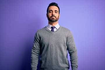 Obraz premium Handsome businessman with beard wearing casual tie standing over purple background Relaxed with serious expression on face. Simple and natural looking at the camera.