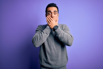 Handsome businessman with beard wearing casual tie standing over purple background shocked covering mouth with hands for mistake. Secret concept.