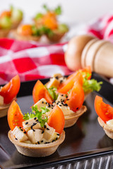 delicious snack tartlets on rustic wooden background