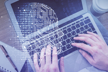 Double exposure of man's hands typing over computer keyboard and brain hologram drawing. Top view. Ai and data technology concept.
