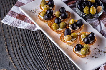 delicious snack tartlets on rustic wooden background