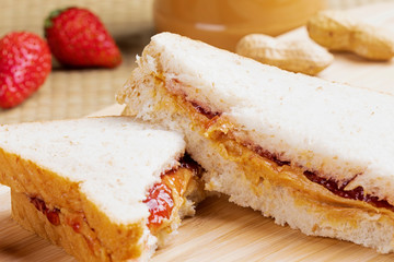 Delicious peanut butter and jam sandwich on a wooden background