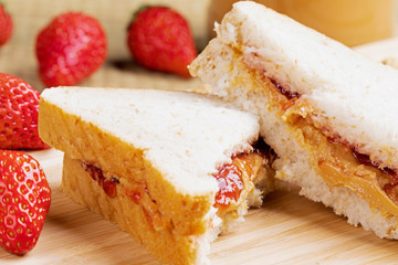 Delicious peanut butter and jam sandwich on a wooden background