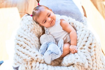 Beautiful infant happy at kindergarten around colorful toys lying inside crib