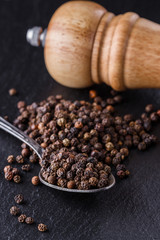 aromatic black pepper on a dark stone background