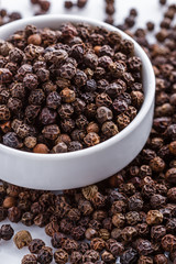 fragrant black pepper on white acrylic background