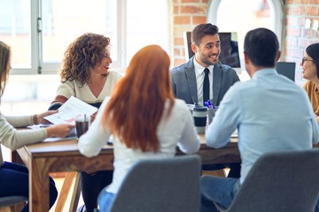 Group of business workers working together. Sitting on desk using laptop reading documents at the office