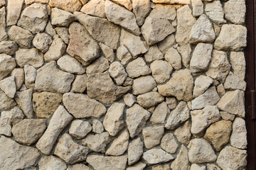 Background of limestone masonry. The surface is decorated with natural material. The wall is made of wild stone.