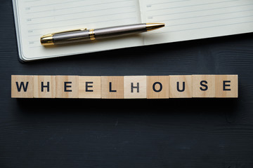 Modern business buzzword - wheelhouse. Top view on a black board with pen and notebook, wooden blocks. Top view. © gesrey