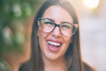 Young beautiful woman smiling happy and confident. Standing with smile on face at the town street