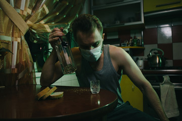 Drinking man with antiseptic and mask