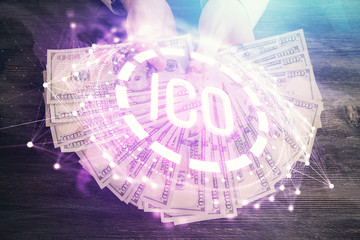 Multi exposure of blockchain theme drawing hologram and USA dollars bills and man hands. Business concept.