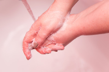 Fototapeta premium Corona virus travel prevention man showing hand hygiene washing hands with soap in hot water for coronavirus germs spreading protection. Covid-19