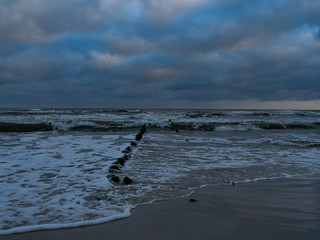 Fototapeta premium After the sunrise at the estuary of the Piasnica River, Poland, Debki beach. Remains of the pier.