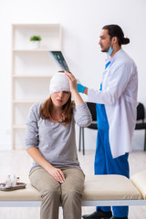 Obraz premium Young head injured woman visiting young male doctor