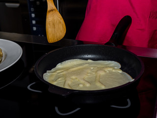 The process of making pancakes. Cook in the kitchen makes the dough