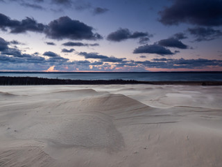 Sunrise on the moving dunes during windy morning. Leba, Poland.