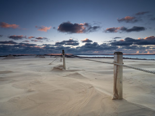 Sunrise on the moving dunes during windy morning.