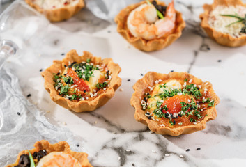 Delicious appetizers in tart with baked egg with cheese on marble banquet table. Catering food, canape and snacks, close up