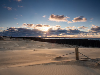Fototapeta na wymiar Sunrise on the moving dunes during windy morning.