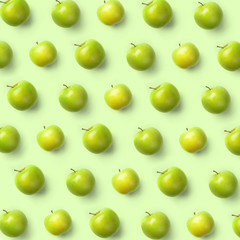 Fresh green apples isolated on green background. Fruits pattern, top view, flat lay