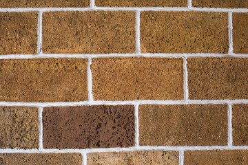 Orange brick wall background. Wall of orange stone with white seams, texture