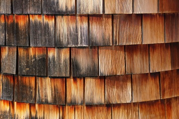 Red and black cedar wood siding of a building