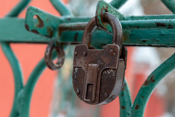 closeup rusty padlock old grille wicket green protection of the territory deadbolt