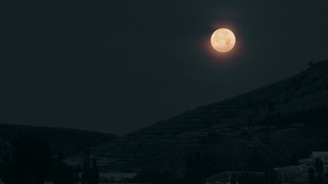 Full moon over the mountain at night