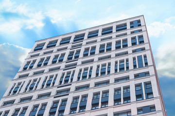 tall building new white windows focus bottom up background sky blue