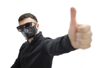 brunette man in sunglasses in a black shirt and a black mask on his face on a white background