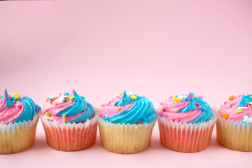 Colorful cupcakes on a pink background