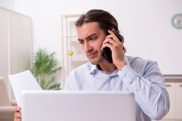Young male businessman working at home