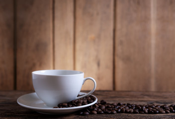 A cup of coffee with coffee bean on wooden background