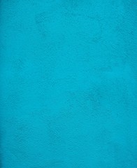 Close up on stucco wall painted turquoise