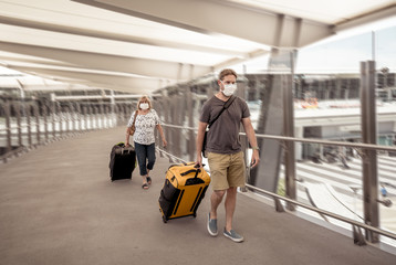 Fototapeta na wymiar Traveler with face mask affected by coronavirus travel ban and COVID-19 pandemic flight restrictions